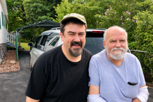 Last photograph of Will Moneymaker and his dad together, standing in a driveway beside a white SUV.